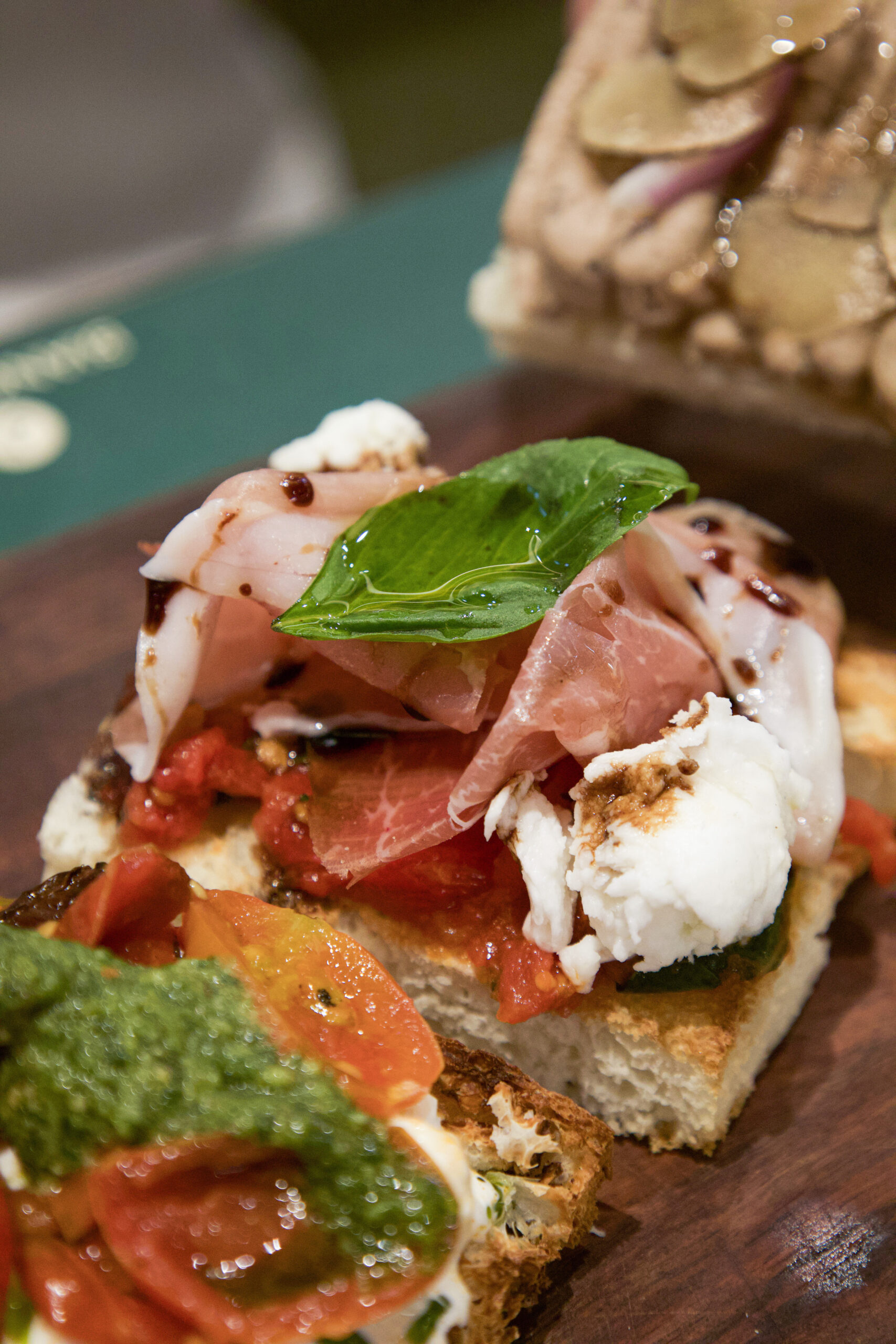 Bruschetta topped with prosciutto, burrata, cherry tomato, basil and pesto at Bianca Bangkok