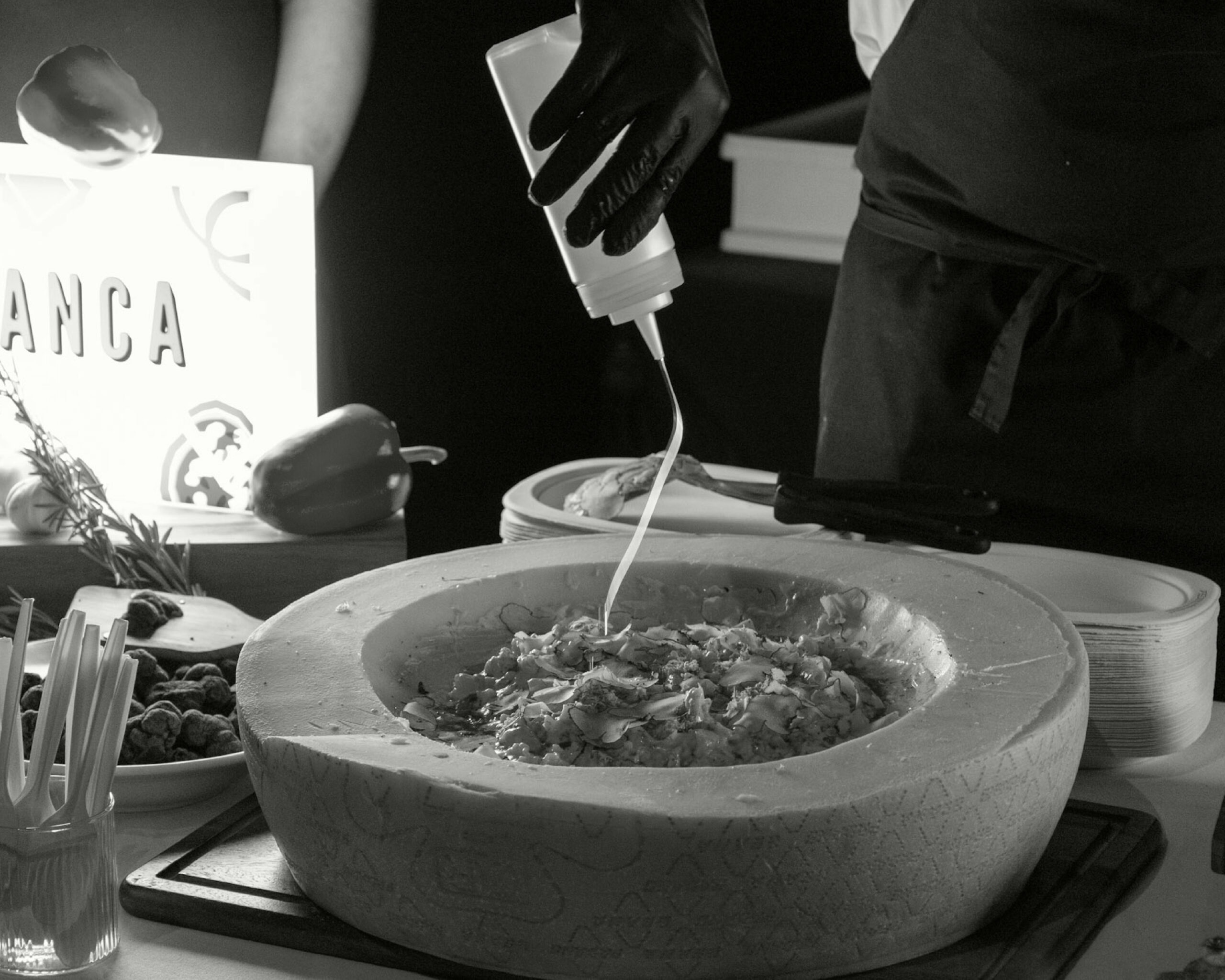 Chef plating pasta in a stone bowl at a Bianca event catering service in Bangkok