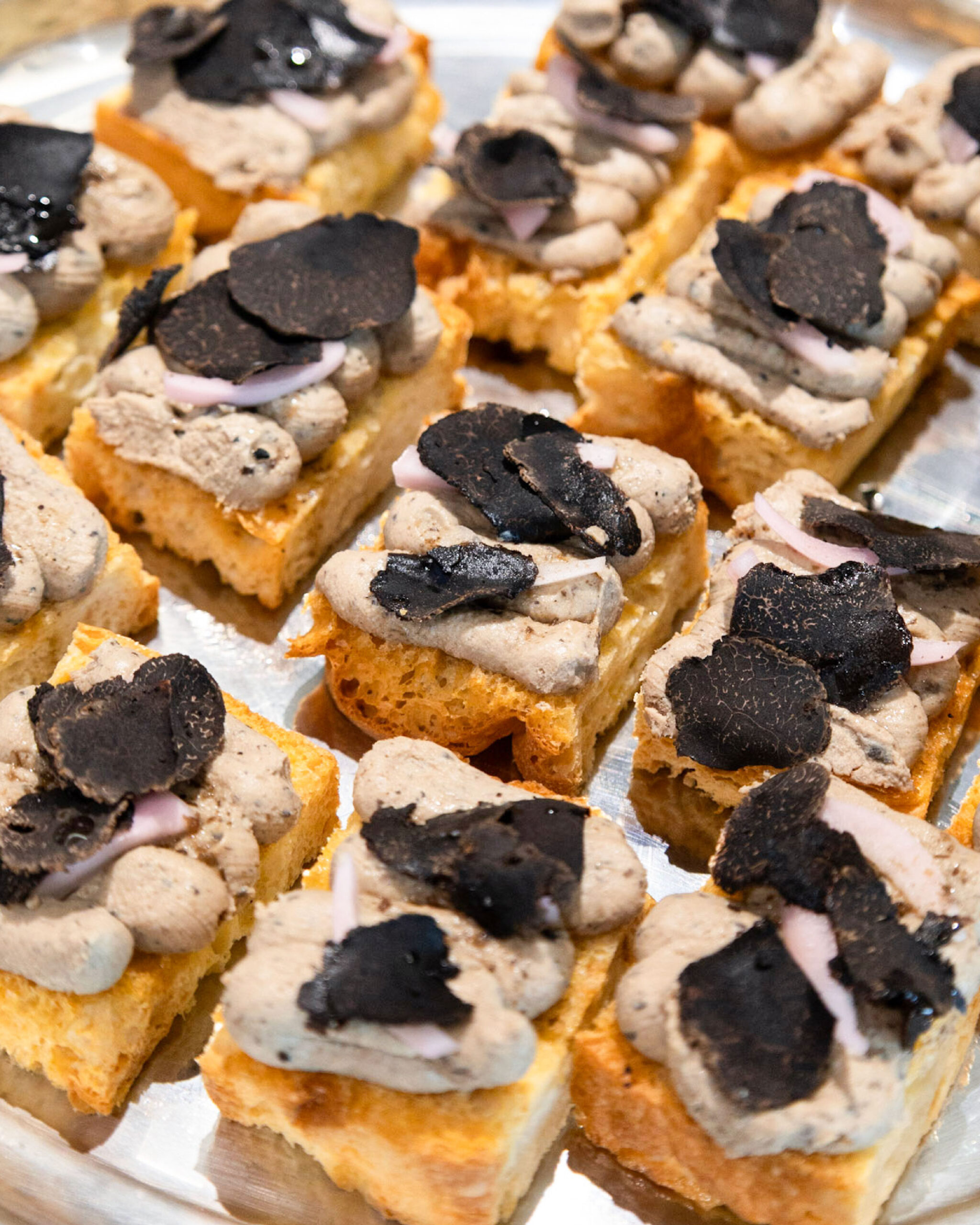 Bianca catering canapés topped with mushroom cream and shaved black truffle